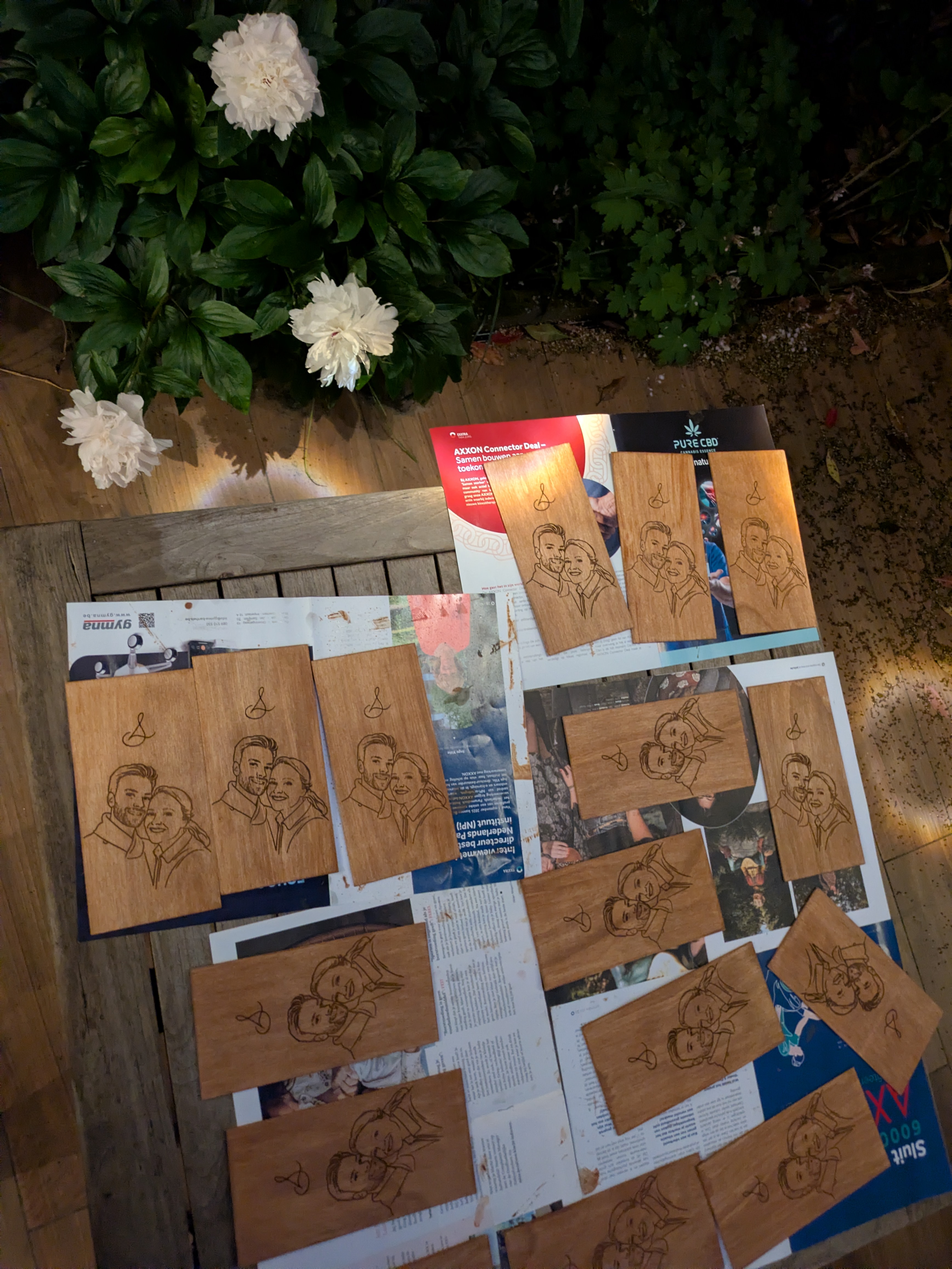 Laser-engraved wooden invitation cards on a garden table